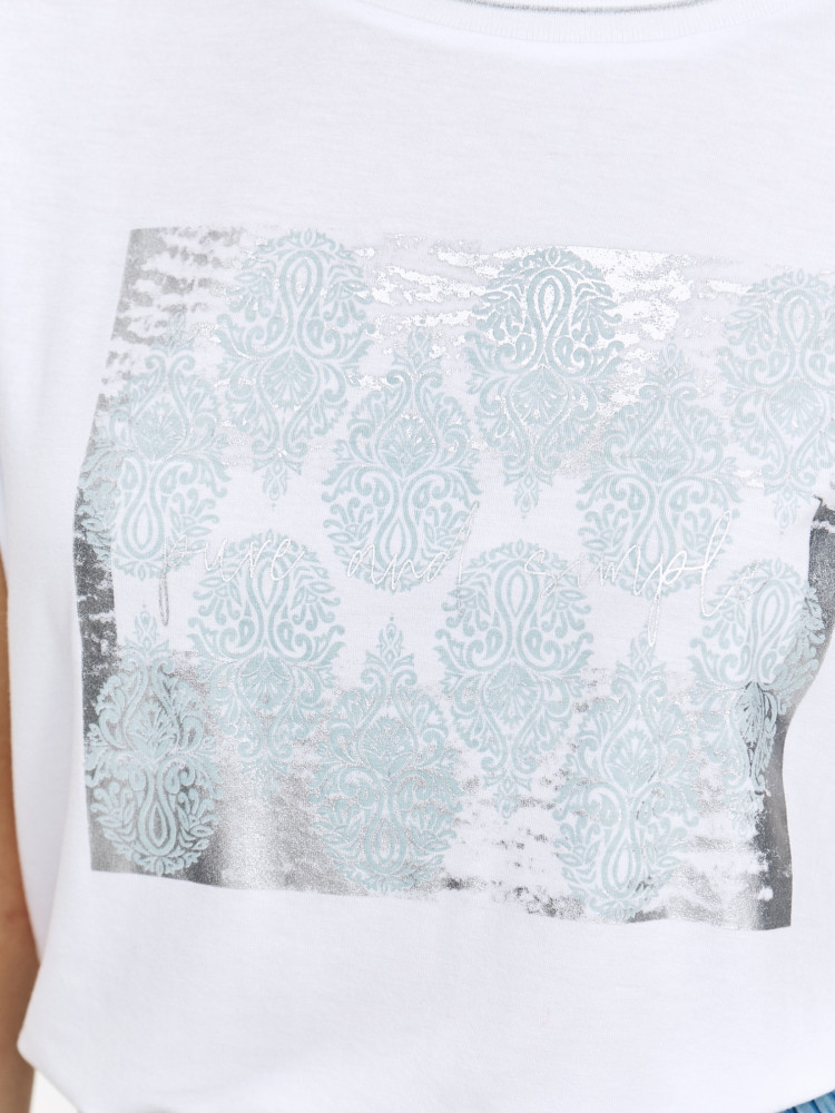 Biały top ze srebrnym nadrukiem na środku 