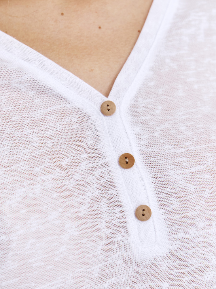 Biały top z kontrastowymi guzikami przy dekolcie 