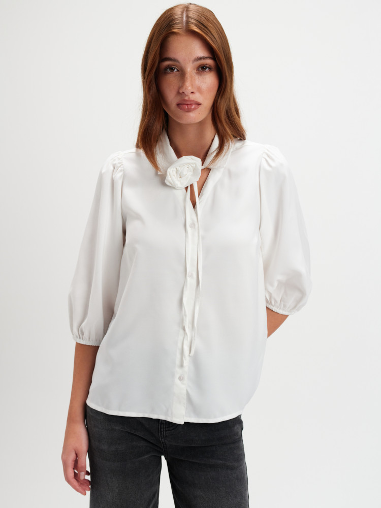 Biała bluzka z dekoracyjnym kwiatem 