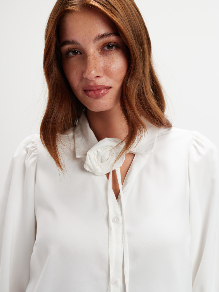 Biała bluzka z dekoracyjnym kwiatem 