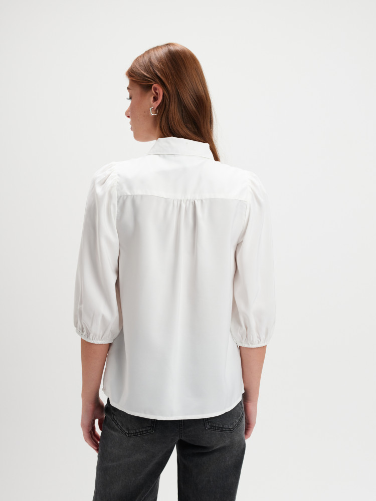 Biała bluzka z dekoracyjnym kwiatem 