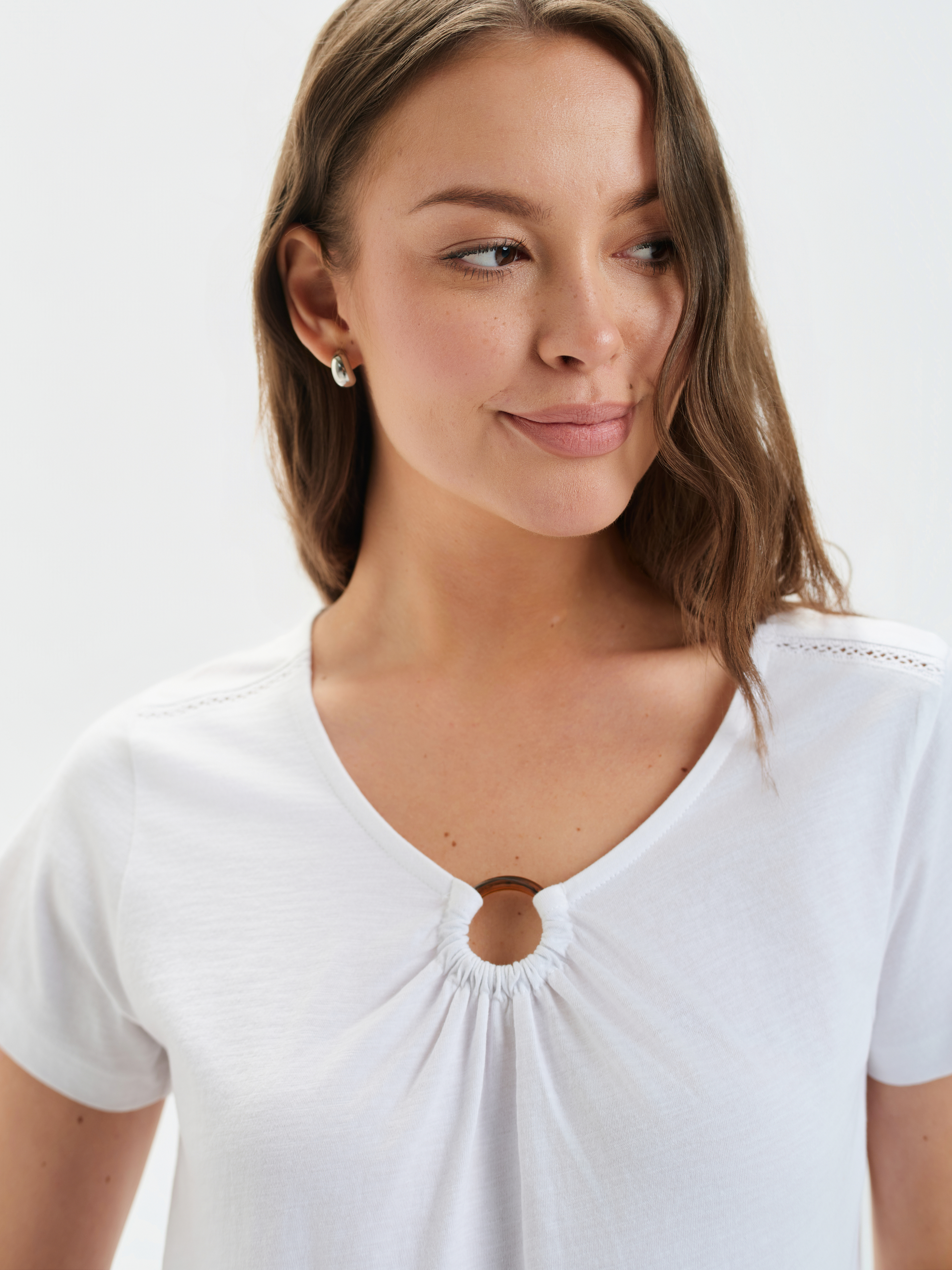 Biały top z aplikacją przy dekolcie 